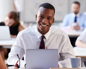 Imagem homem em ambiente de escritório sorrindo.